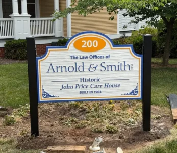 Signboard for The Law Offices of Arnold & Smith in front of a historic house (John Price Carr House, built 1903).